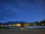 Exterior, Flat RoofLine, Stucco Siding Material, Glass Siding Material, Metal Roof Material, House Building Type, Concrete Siding Material, Wood Siding Material, and Hipped RoofLine Exterior at dusk  Photo 6 of 10 in Wailupe Home Remodel by ADM Architecture + Interiors