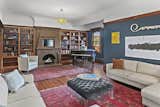 Built-in bookshelves flank the artisan-painted brick fireplace and mantel of the magnificant living room/parlor.
