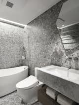 Bath Room, Metal Counter, Terra-cotta Tile Floor, Stone Counter, Drop In Tub, One Piece Toilet, Open Shower, Ceiling Lighting, Stone Tile Wall, Tile Counter, and Drop In Sink  Photos from The Invisible Order of Daily Life