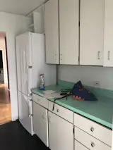 Before: Low, above-counter cabinets made the space feel cramped. Aim<span style="font-family: Theinhardt, -apple-system, BlinkMacSystemFont, "Segoe UI", Roboto, Oxygen-Sans, Ubuntu, Cantarell, "Helvetica Neue", sans-serif;">ée</span><span style="font-family: Theinhardt, -apple-system, BlinkMacSystemFont, "Segoe UI", Roboto, Oxygen-Sans, Ubuntu, Cantarell, "Helvetica Neue", sans-serif;"> took a note from the existing color-blocked counters in her new design, helping stay true to the original spirit of the space.</span>