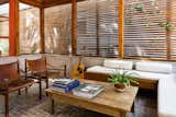 The screened porch provides a covered outdoor space that is still open to the elements. Scott built many of the furnishings himself, including the coffee table and integrated bench.