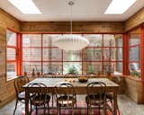 Capturing a 1970s West Texas sunroom vibe, the new dining room combines reclaimed wood and brick with custom painted steel windows for a seamless integration of old and new. "Our north star was to use a modern sensibility to create something that looked like it had always been here,