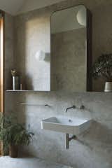 Bath Room, Wall Mount Sink, Stone Tile Wall, and Wall Lighting  Photos from A Couple’s Home in Australia Is a Canvas for Changing Light