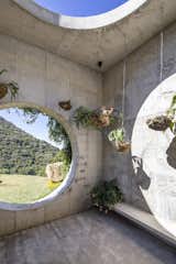 In the remote mountains of Palmichal de Acosta, Costa Rica, local architect María de la Paz Alice, founder of Mazpazz Arquitectura, designed a 100 percent autonomous and self-sustaining home that frames its lush surroundings with a series of geometric openings. The home’s entrance, which the architect refers to as “the vortex,” takes the form of a poured-concrete cube with two prominent circular cutouts. Crystals encrusted in the floor capture and reflect light that passes from the sun and moon through the overhead oculus.