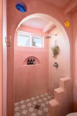 The color pink is featured prominently throughout the house, particularly in the primary bathroom. "I used pink for the walls because it absorbs the surroundings, especially during sunset," says Button.