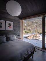 The north-facing bedroom enjoys a view of the elevated pool, which sits at the end of an elevated pier jutting into the forest.