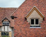 The addition's dormer windows offer a modern take on the original farmhouse's fenestration.