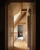 Upstairs, a narrow bridge walkway overlooks the dining and living areas below while allowing light to flood into the core of the space.