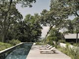 The pool's long, rectangular shape mimics the verticality of the main living structure just beyond.
