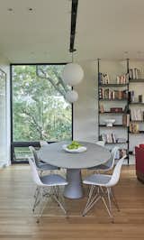 Instead of a kitchen island, an ovoid dining table provides definition between the kitchen and the living room.  The dining table is from Bontempo and the overhead pendants are by DePadova.