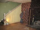 The original living area had vintage wallpaper and a dark stone fireplace.