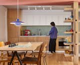 Studio Becker Xu streamlined the kitchen by building all of the appliances into the millwork. The budget-friendly countertops are a Formica solid surface.