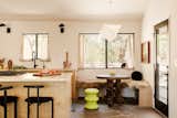 A new breakfast nook off the kitchen creates space for casual dining. Replacing a sliding door with a single opening created more space for seating, while still offering ease of access to the patio. The neon green stool is Kartell Pilastro from Design Within Reach, and the table is vintage from Laguna Vintage.