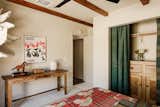 In the guest room, a vintage French country wooden hutch in the closet and a vintage rustic wooden table were both sourced from the Rose Bowl Flea. The closet drapes are from Etsy.