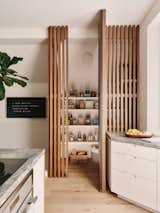 The slat wall opens to reveal a kitchen pantry.