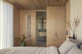 The primary bedroom continues what the architect describes as an "essay in wood,