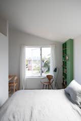 In the primary bedroom, Eric crafted a desk from birch plywood and a chair from maple. The lamp is by Greta Grossman and the chair next to it is from Cherner.
