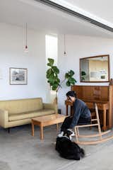 In the living area, Eric’s wife sits on a rocker he crafted from maple. The couch is from Design Within Reach and the coffee table is by Roy McMakin. The pendant lights are from Muuto.