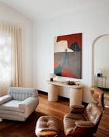 Amanda reupholstered the low, striped chair after discovering it at a garage sale. The living room painting is by Ali Valenti.