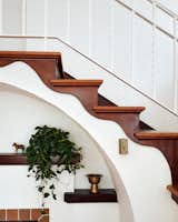 The stair’s wavy wood detail also influenced the scalloped ceilings in the kitchen and dining room.