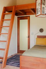 In the second bedroom, a custom built ladder leads to a loft area with a custom built bed below. The casework is all old growth Redwood and was fabricated by Michael Mellon and Benjamin Winslow. The bedding is from Morrow Goods and the rug is from Slow Roads.