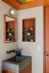 The home's single bathroom contains a vanity and mirror fabricated from old growth Redwood. The sink is cast concrete, and the faucet is from California Faucets. The inset wall shelf contains a Japanese gouge texture done by Nick.
