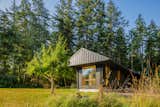 Ets Architecture designed a cabin on Lopez Island that is split into three separate structures connected via breezeway and a raised boardwalk.
