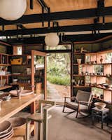 The ceramics studio’s enclosure consists of a roof elevated off the original rafters, and glazing applied directly to shelves that are suspended between the original columns. 