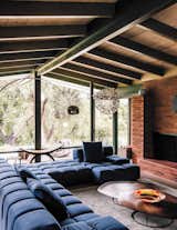 While the property was sold to Mary Blodgett and Carlton Calvin as a teardown, the couple saw its potential. "It was falling apart, but gorgeous," recalls Mary. "I’m a preservationist when I can be." In the living room of the main house, a sofa by Patricia Urquiola surrounds a Nathan Young coffee table, capped with a floor lamp by Achille Castiglioni. 