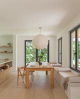 Monica sourced the solid oak dining table from Poland while on a family trip. 1960s vintage Aldo Jacober folding chairs complement a built-in banquette. The pendant light is from Tala Lighting.