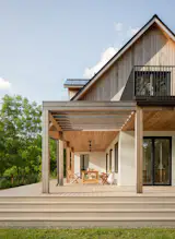 The roof has the added benefit of providing cover for an outdoor dining space, which connects to the larger wraparound deck.