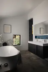 In the primary bath, a Porcelanosa tub complements a blackened veneer vanity.