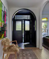 The architects created arched doorways throughout the home's lower level in keeping with the historic character of the house.  The mosaic tile at the entry has a custom "Welcome