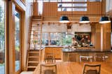 The kitchen sits underneath a workloft accessible by a wooden ship's ladder. Callie's dad Trevor Hilpert fabricated the ladder and much of the loft casework in his San Juan Island woodshop.