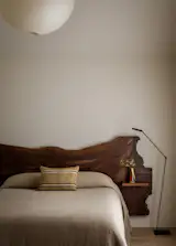 In the primary bedroom, Smith designed a custom walnut live edge headboard from <a href="http://www.nvhardwoods.com">Napa Valley Hardwoods</a>. The pendant is a Noguchi Akari light.