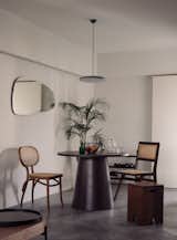 Dining Room, Concrete Floor, Pendant Lighting, Table, and Chair Dark timber and rattan furniture were selected to warm up the cool tones of the home.  Photo 5 of 16 in Vignettes by Lam Jun Nan