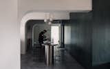 Kitchen, Marble Counter, Metal Cabinet, Pendant Lighting, and Concrete Floor Anchoring the living and kitchen space is a 5-metre long island counter where myriad of activities happen. Architectural elements like the arch cornice at the junction of the existing columns and beams were layered into the space to add a soft charm and character to the apartment.  Photo 7 of 16 in Vignettes by Lam Jun Nan