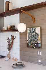Kitchen, Ceramic Tile Backsplashe, Wood Backsplashe, Engineered Quartz Counter, and Wall Lighting Vintage lighting evokes the home's original 1951 design.  Photo 9 of 17 in Charles Goodman Home XV by Cook Architecture