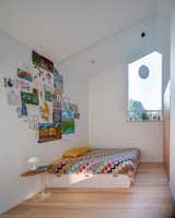 Custom window in the child's bedroom balances privacy with a framed view of the sky