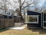 Shared materials, such as unpainted cement panels, Shou Sugi Ban siding, and site-built Douglas Fir window frames, help unify the architectural language of the two homes