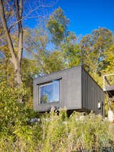 Exterior The two structures are wedded with the black, board and batten exteriors and utilize off-grid geothermal heating, well water, and evaporative septic.  Search “geothermal” from Michigan Residential Cabana and Pool