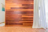 Restored redwood wall, warm cork floor , sheer cotton gauze creates a calm ing, organic retreat-like 
bedroom.