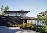 The front entry sequence transitions from the parking area to front door, with a secondary path from the driveway down to the back yard. The landscape architects chose steel planters to house the maple, fern, and other plantings, for durability and a pleasing weathered look.
