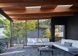 The horizontal lines of the rail and wall and the color scheme of blacks and browns add a Japanese aesthetic to the entry indoor/outdoor room and create a bold interplay of light and shadow throughout the day.