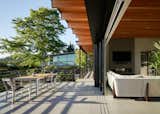 The beams in the great room extend to the deck beyond. The deck is flush with the living room and composed of the same tile for a seamless transition between inside and out.