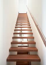 The upper floor is reached by a custom floating staircase with an operable skylight for light and ventilation. The handrail is underlit with LED lighting.