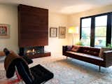 Three sided glass enclosed gas fireplace faced in walnut that is able to go right to the edge of the firebox.  Fireplace by Regency.