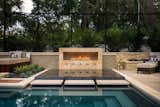 The luxurious infinity spa allows guests a front row seat to the waters and fire of the custom linear feature.  Stepping pads offer easy access to the spa and adjacent lounge areas. The spa is hand clad with shimmering decorative glass tiles. 