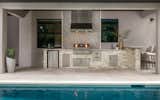 The outdoor kitchen area is clad in MSI Ledgestone and outfitted with stainless steel appliances and a Fire Magic grill.  