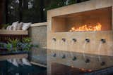 Mirrored in the waters of the spa are the fountains and flames of this luxury designed modern fire and water feature. 